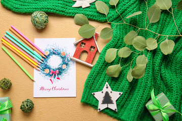 Beautiful composition with greeting card for Christmas celebration and sweater on color background