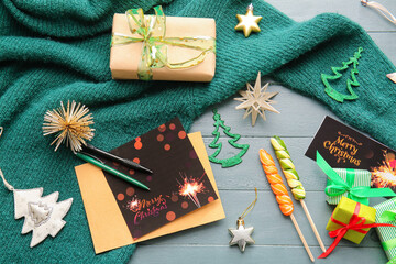 Beautiful greeting cards for Christmas celebration, gifts and sweater on wooden background
