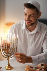 Man lighting candles for Hannukah at home