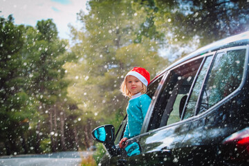 christmas car travel- happy cute baby girl loves travel in winter