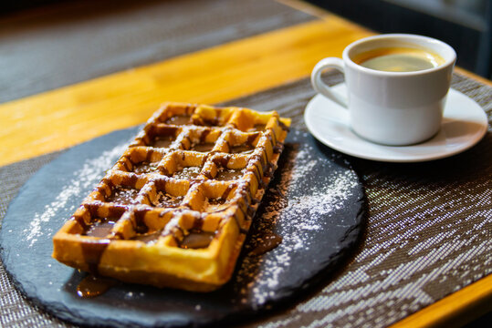 Cup of coffee and Belgian waffles with chocolate