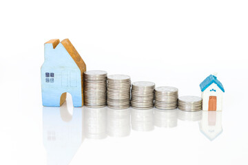 Minature house with stack of coins on white background, property business, banking industry, house...