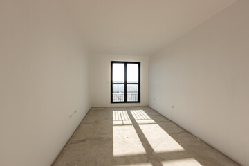 New empty room under construction. Plaster walls. New home. Concrete walls. Interior renovation.