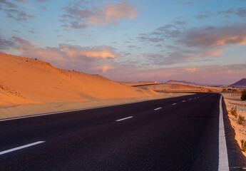 Fototapeta premium scenic road that runs through the sand dunes of Fuerteventura