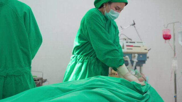 Group of Asian professional surgeons and nurses team making CPR.