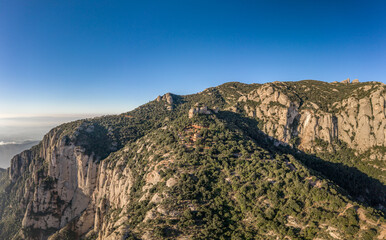 Panoramic aerial drone view of Holy Cave of Montserrat on mountain near Barcelona in sunrise