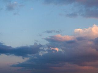 Whimsical clouds in the blue sky. Summer evening