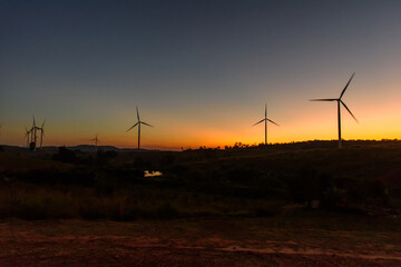 wind turbines park for make the electric power from wind in sunset time