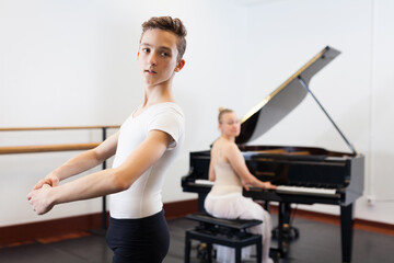 Fototapeta na wymiar Ballet lesson in the studio. Choreographer plays the piano