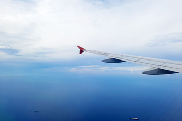 Fototapeta premium A beautiful view of blue ocean with ship viewed from an airplane window