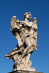 Fototapeta na wymiar Angel with the Superscription statue on Ponte Sant Angelo bridge in Rome, Italy. Marble sculpture from 17th century, design of Gian Lorenzo Bernini