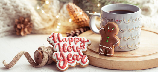 Christmas composition with beautiful cup and gingerbread cookies with happy new year wishes.