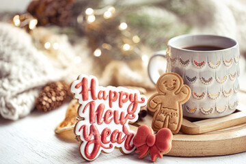 Christmas composition with beautiful cup and gingerbread cookies with happy new year wishes.
