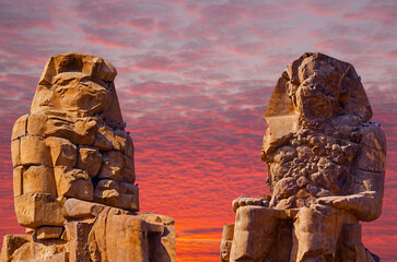Colossi of Memnon Luxor Thebes against the background of dawn in the Egypt