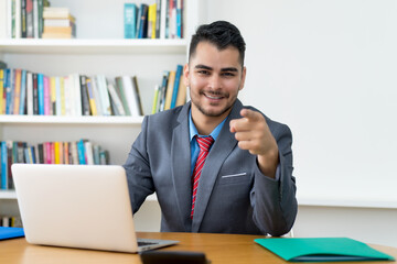 Laughing mexican businessman at computer at office