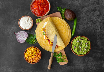 Tortilla wrap or burrito with corn, beans, greens, and homemade guacamole. Vegetarian healthy food, Mexican cuisine