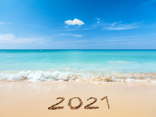 Fototapeta na wymiar 2021 written on sandy beach