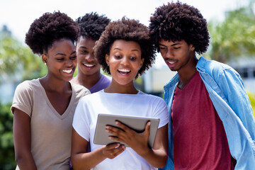 Happy african american young adults streaming movie with digital tablet