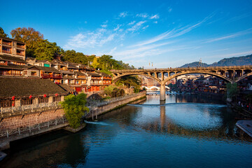 the river, the boat, stone bridge and the old houses at ancient phoenix town in the morning at Hunan, China.