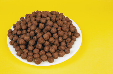 chocolate balls in a plate on a yellow background