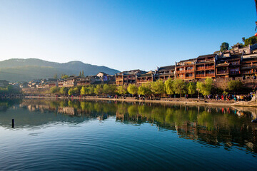 Fototapeta premium the river, the boat, stone bridge and the old houses at ancient phoenix town in the morning at Hunan, China.