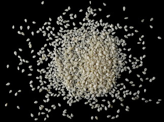Sesame seeds pile isolated on black background, top view