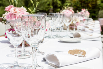 Wedding table decorated with bouquet of pink flowers and wine glasses