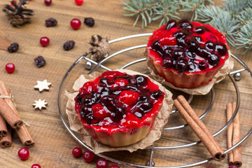 Berry muffins on metal tray. Cinnamon sticks, raisins and cranberries on table. Fir branches