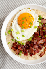 Homemade Cheesy Bacon Savory Oatmeal Bowl on cloth, top view. Overhead, from above, flat lay.