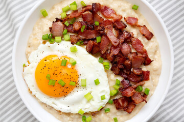 Homemade Cheesy Bacon Savory Oatmeal Bowl on cloth, top view. Overhead, from above, flat lay. Close-up.