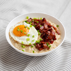 Homemade Cheesy Bacon Savory Oatmeal Bowl on cloth, side view.