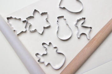 christmas cookie cutters on white colored paper backgound. top view . close up