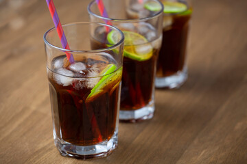 Cocktail Cuba Libre closeup on wooden table, close up