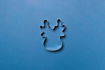 cookie cutter in form of deer on blue colored paper background. isolated. close up. mock up