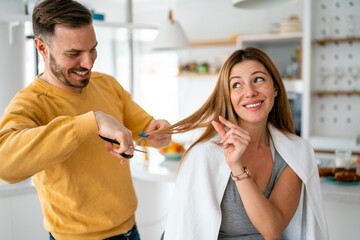 Man makes haircut to woman at home during quarantine.