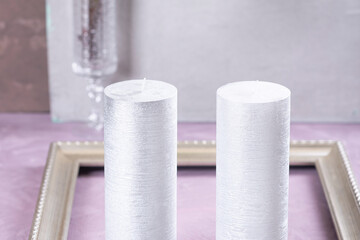 Silvery candles on a beige table with flowers