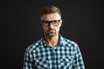 Obraz premium Handsome confident man in eyeglasses posing and looking at camera