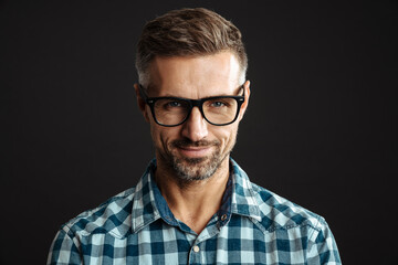 Handsome pleased man in eyeglasses smiling and looking at camera
