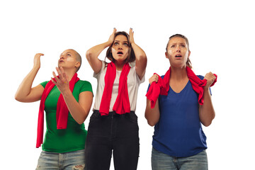 Obraz premium Stress. Female soccer fans cheering for favourite team with bright emotions isolated on white studio background. Beautiful caucasian women look excited, supporting. Concept of sport, fun, support.