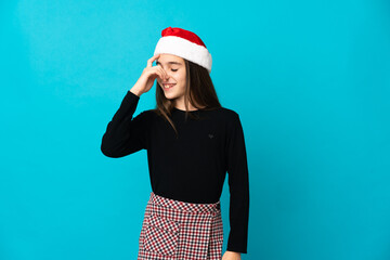 Little girl with Christmas hat isolated on blue background laughing