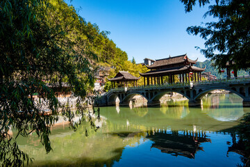 the river, the boat, stone bridge and the old houses at ancient phoenix town in the morning at Hunan, China.