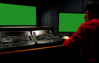 Men edit videos in a dark studio using modern color grading tools and equipment.Selective focus.Colour Grading. green screen.                        
