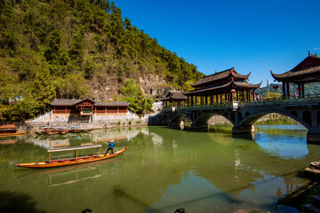 the river, the boat, stone bridge and the old houses at ancient phoenix town in the morning at...