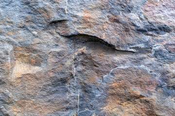 Multicolored rock wall. Stone textured surface close-up. Copy space. Abstract natural background.