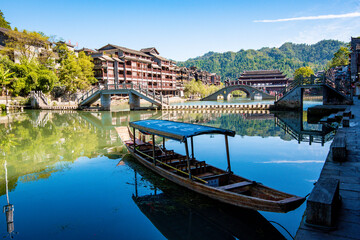 Obraz premium the river, the boat, stone bridge and the old houses at ancient phoenix town in the morning at Hunan, China.