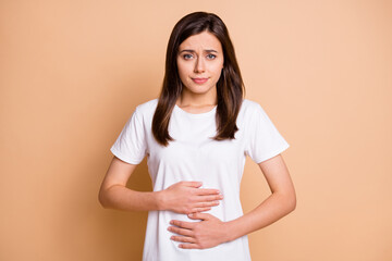 Photo portrait of unwell young woman got bellyache poisoning tummy spasm isolated pastel beige color background