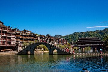 the river, the boat, stone bridge and the old houses at ancient phoenix town in the morning at Hunan, China.