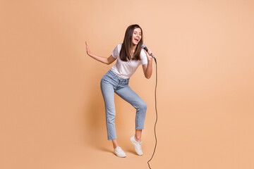 Full length body size photo of female pop star singing song keeping mic dancing on stage isolated...