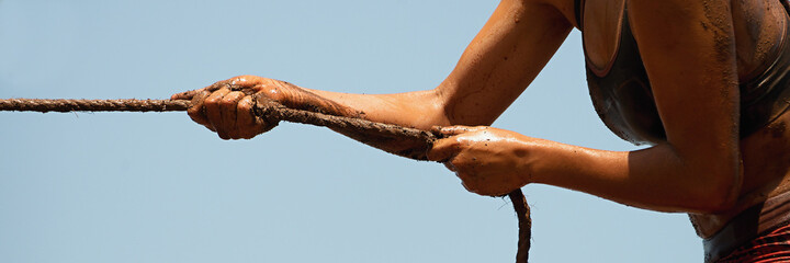 Mud race runners,defeating obstacles by using ropes