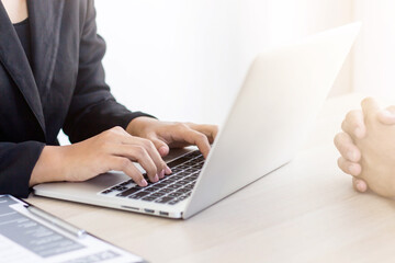 Manager typing information on laptop during job interview job applicant.